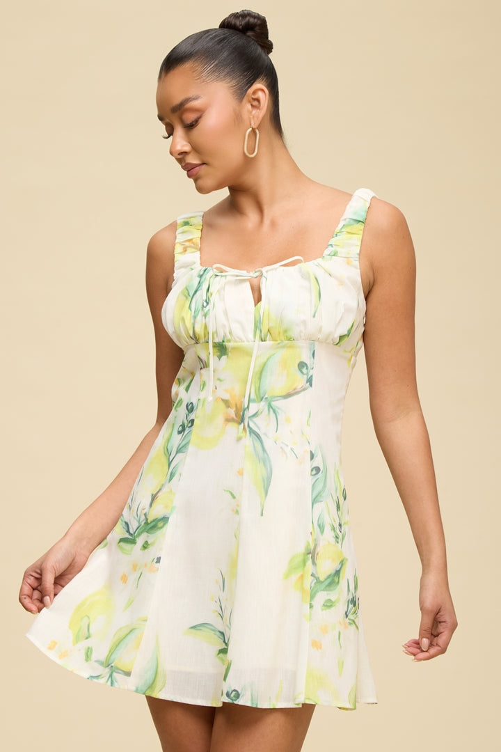 Lemon print ruched bust tie-front flowy mini dress - front view showing tie detail and flared skirt
