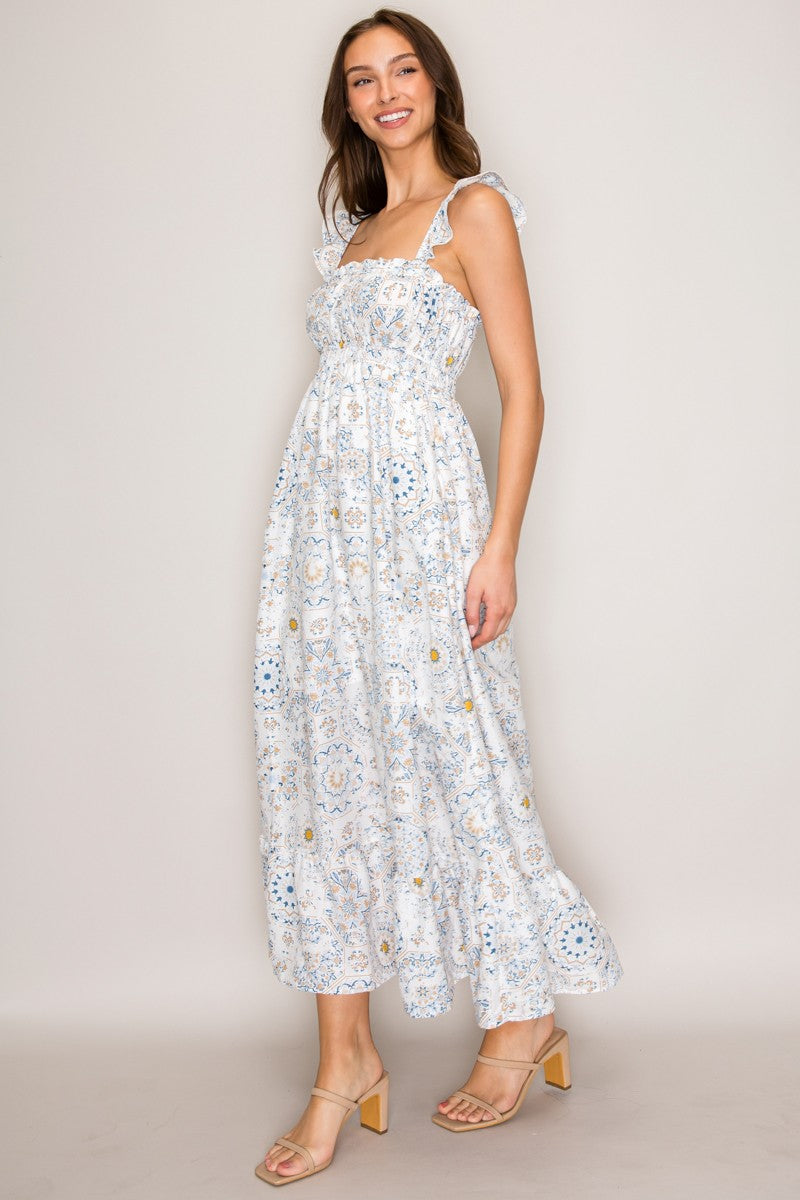 White botanical tile-print square-neck ruffle-strap smocked-bodice tiered midi dress - side three-quarter view showing ruffle-edged strap profile, smocked bodice silhouette, and full tiered midi skirt from the side in white botanical tile print