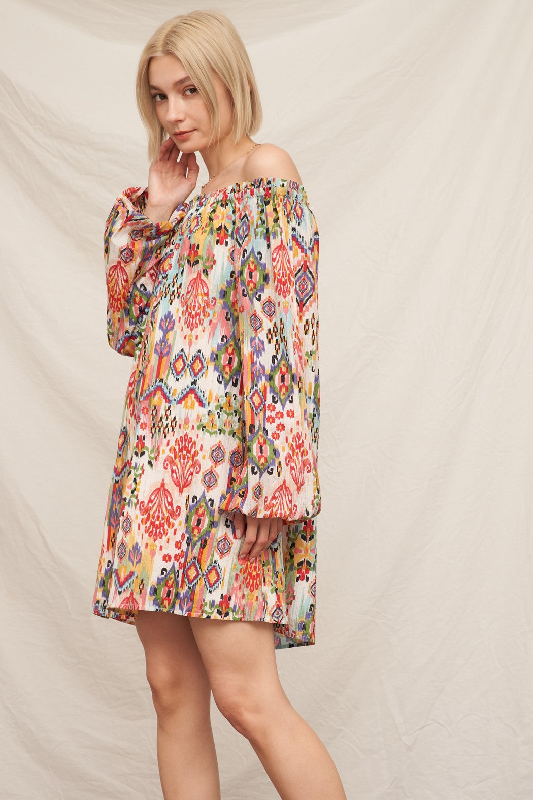 Multicolour ikat print off-shoulder long bishop-sleeve babydoll mini dress - side view showing bishop sleeve volume and A-line silhouette