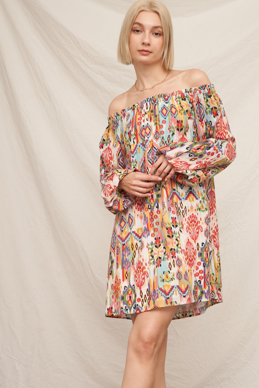 Multicolour ikat print off-shoulder long bishop-sleeve babydoll mini dress - front full view showing off-shoulder neckline and flowing silhouette