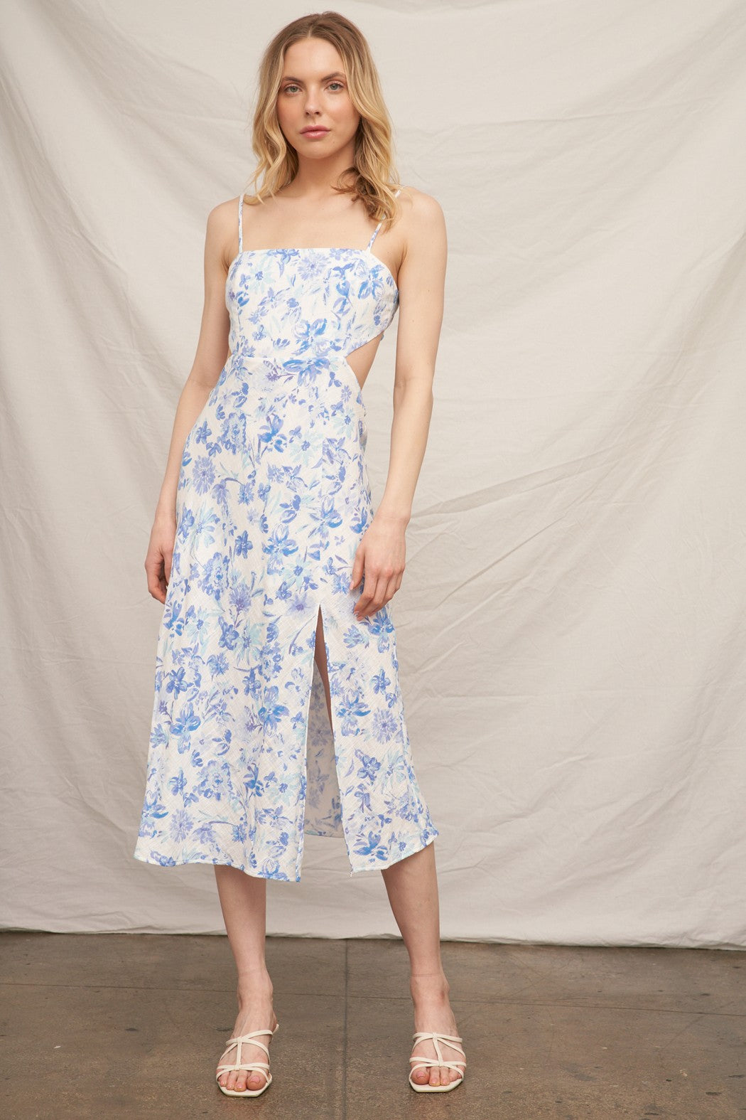 Blue floral spaghetti-strap square-neck side-cut-out back-bow-tie front-slit midi dress - alternate front full view showing square neckline, spaghetti straps, side cut-out waist detail, front slit, and blue botanical floral print on white midi skirt