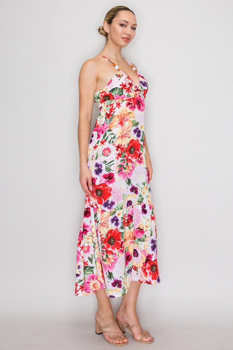 Tropical floral beaded-halter deep-V ruched-bust open-cross-back tiered midi dress - side three-quarter view showing beaded halter straps, deep-V bodice, ruched bust, fluid tiered skirt silhouette, and white-ground tropical floral print from the side