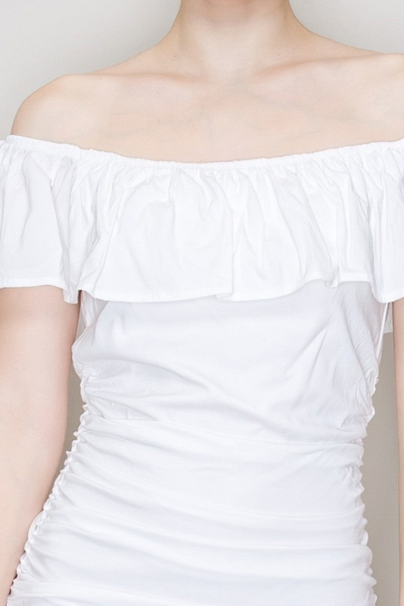 White off-shoulder ruffle-collar allover-ruched bodycon mini dress - close-up bust detail showing wide gathered off-shoulder ruffle collar, smooth bodice beneath, and dense ruching beginning at waist