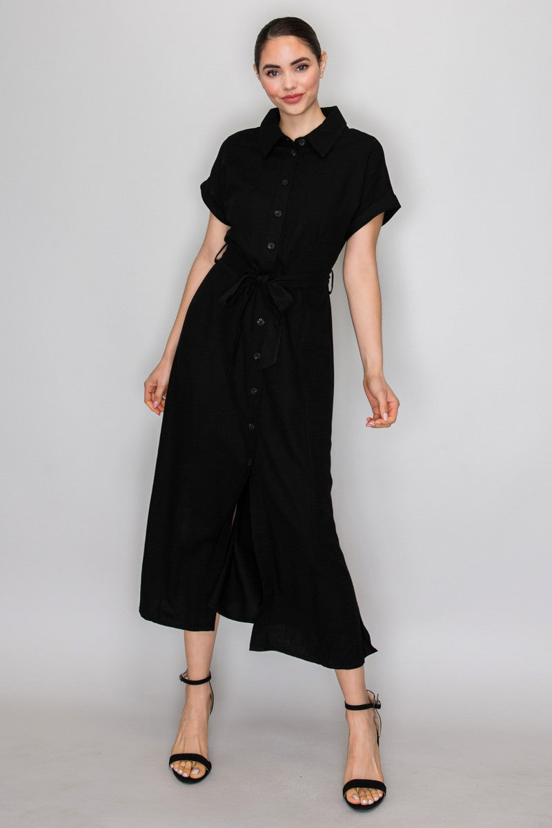 Black short-sleeve shirt-collar button-front belted side-slit maxi dress - close-up bodice detail showing crisp pointed shirt collar, tonal black buttons on centre-front placket, short cuffed sleeves, and self-tie belt at natural waist