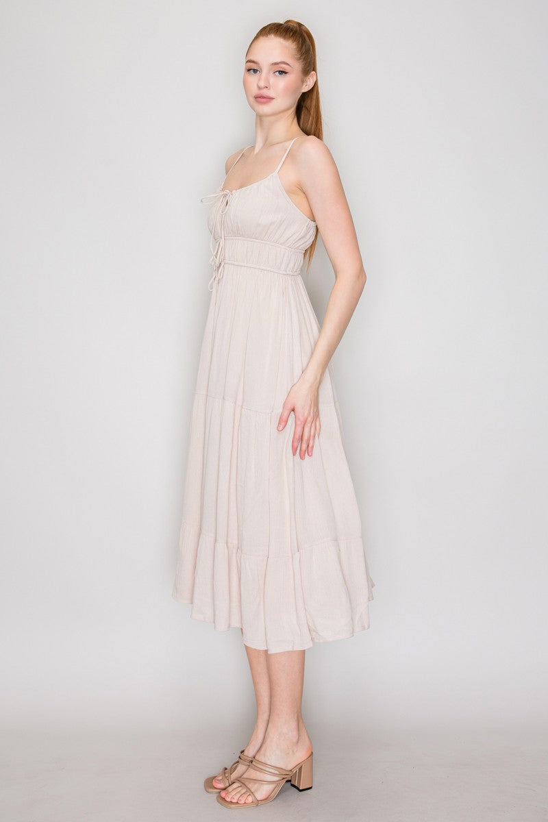 Cream crinkle chiffon spaghetti-strap lace-up corset-bodice tiered midi dress - side full view showing adjustable spaghetti straps, ruched bodice profile, wide waistband, and full tiered midi skirt silhouette in motion