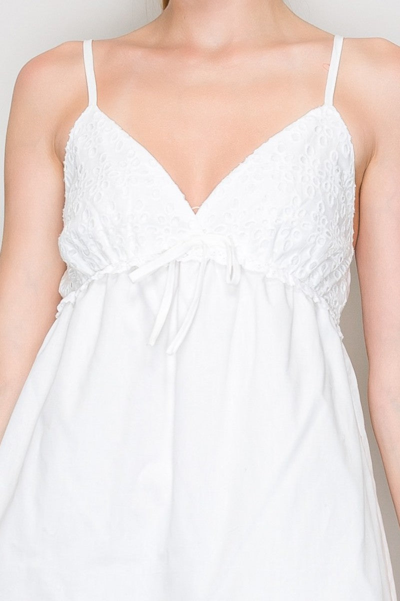 White Swiss dot V-neck bow-front empire-waist tiered babydoll mini dress - front full view showing V-neckline gathered bust, dainty bow, double spaghetti straps, full tiered babydoll skirt, and ruffle hem in white