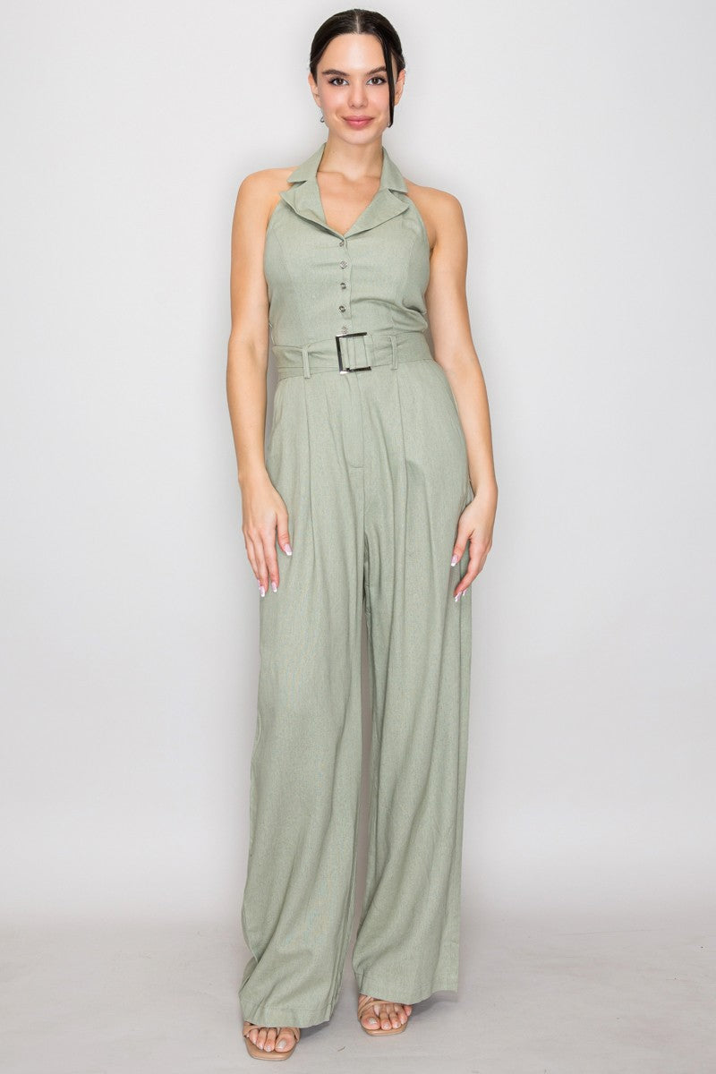 Blush pink halter-collar button-front belted wide-leg jumpsuit - front full view showing open shirt collar, halter neck tie, centre-front metallic buttons, square-buckle belt at waist, and wide-leg trouser silhouette in blush pink