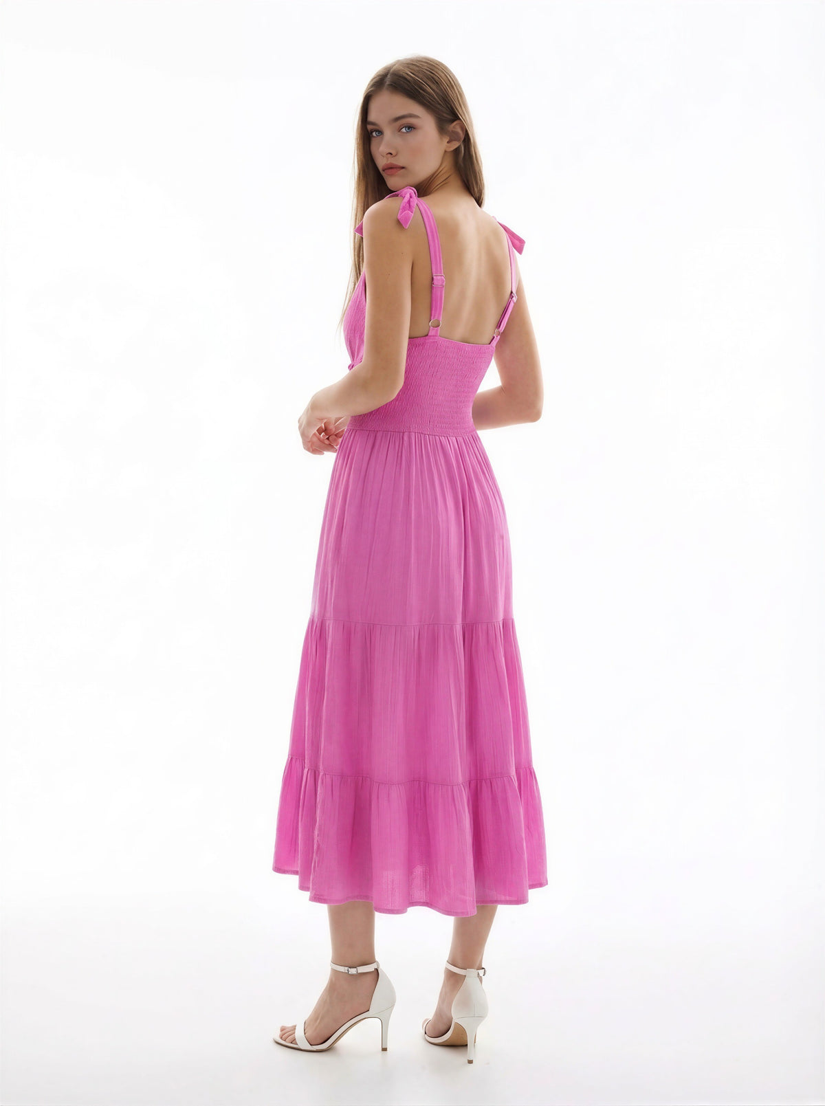 Hot pink V-neck tie-shoulder smocked-waist tiered midi dress - additional back view showing tie-bow strap detail at shoulders, smocked back, and full tiered skirt volume from behind in hot pink