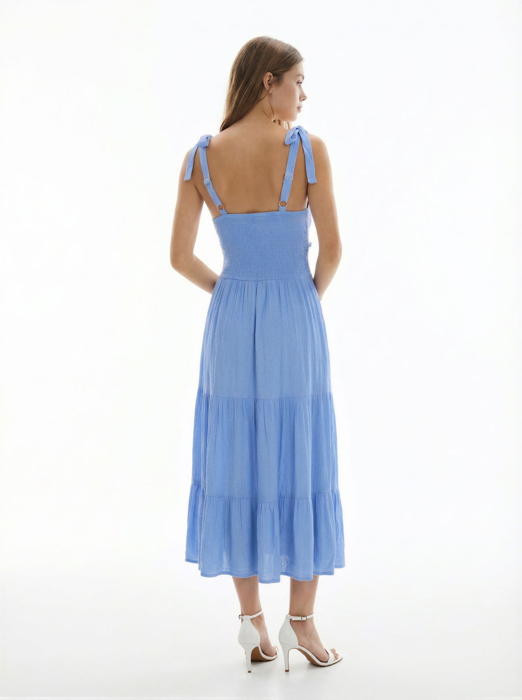 White V-neck tie-shoulder smocked-waist tiered midi dress - back full view showing tie-bow straps at each shoulder, smocked back bodice, and generous tiered midi skirt from behind in white