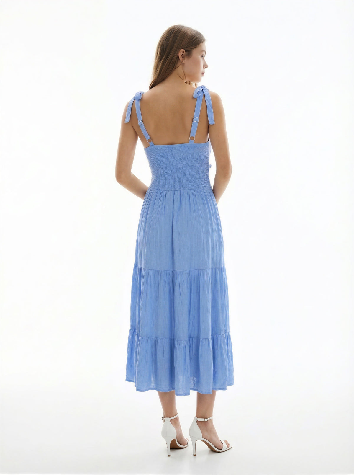 White V-neck tie-shoulder smocked-waist tiered midi dress - back full view showing tie-bow straps at each shoulder, smocked back bodice, and generous tiered midi skirt from behind in white