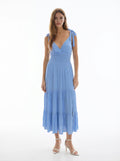 White V-neck tie-shoulder smocked-waist tiered midi dress - side three-quarter front view showing V-neckline, tie-bow shoulder strap, smocked bodice, and full tiered midi skirt silhouette in white