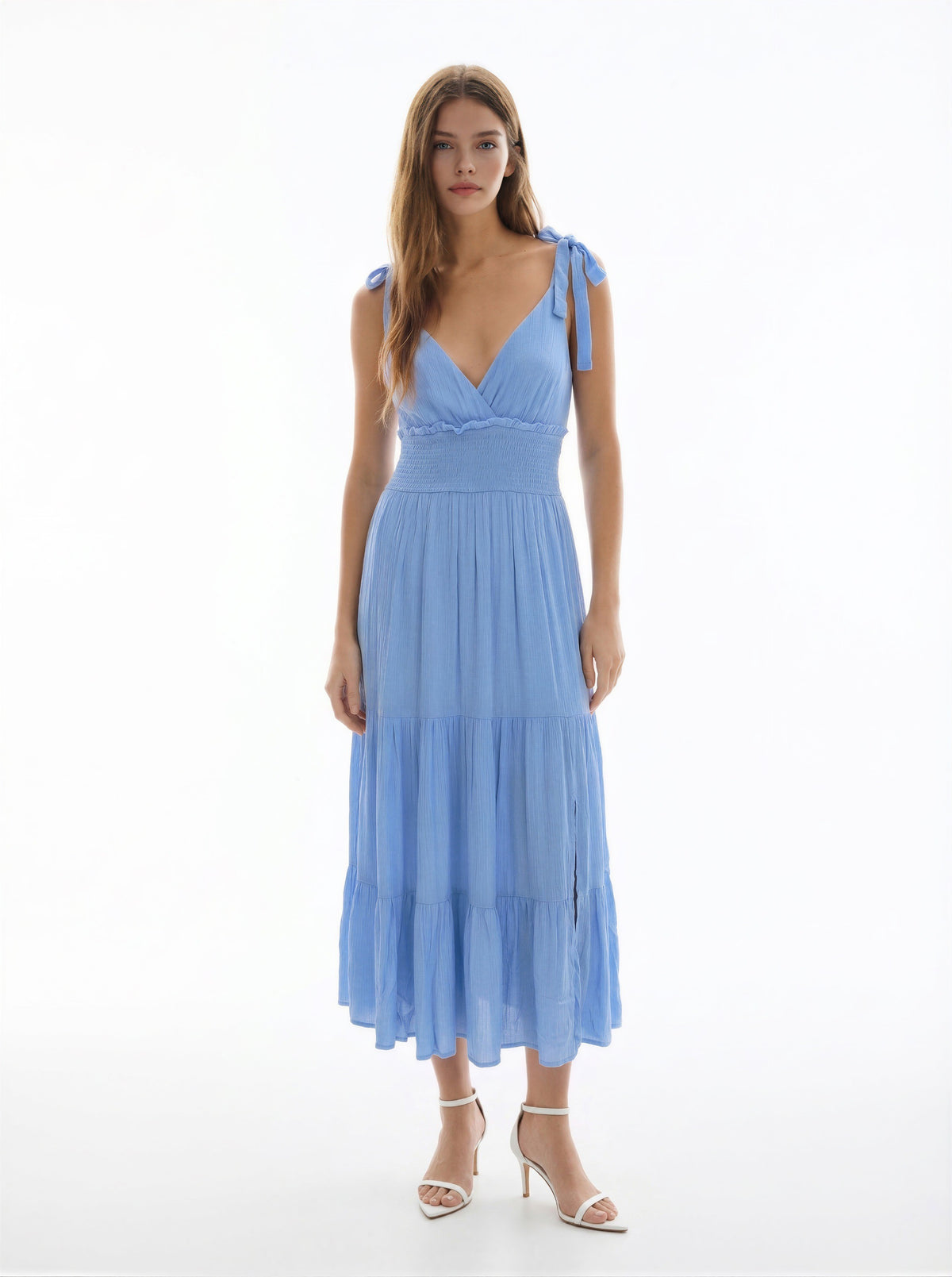White V-neck tie-shoulder smocked-waist tiered midi dress - side three-quarter front view showing V-neckline, tie-bow shoulder strap, smocked bodice, and full tiered midi skirt silhouette in white