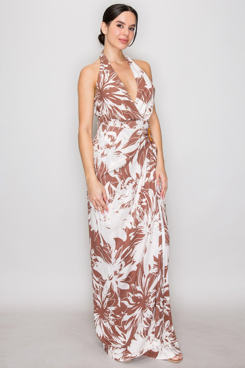 Mocha tropical floral halter deep-V wrap-bodice rattan-ring-buckle wide-leg jumpsuit - front full-length view showing dramatically plunging deep-V halter neckline, wrap-cross bodice, woven rattan ring buckle at side waist, and ultra-wide palazzo legs in large-scale mocha and cream tropical floral print