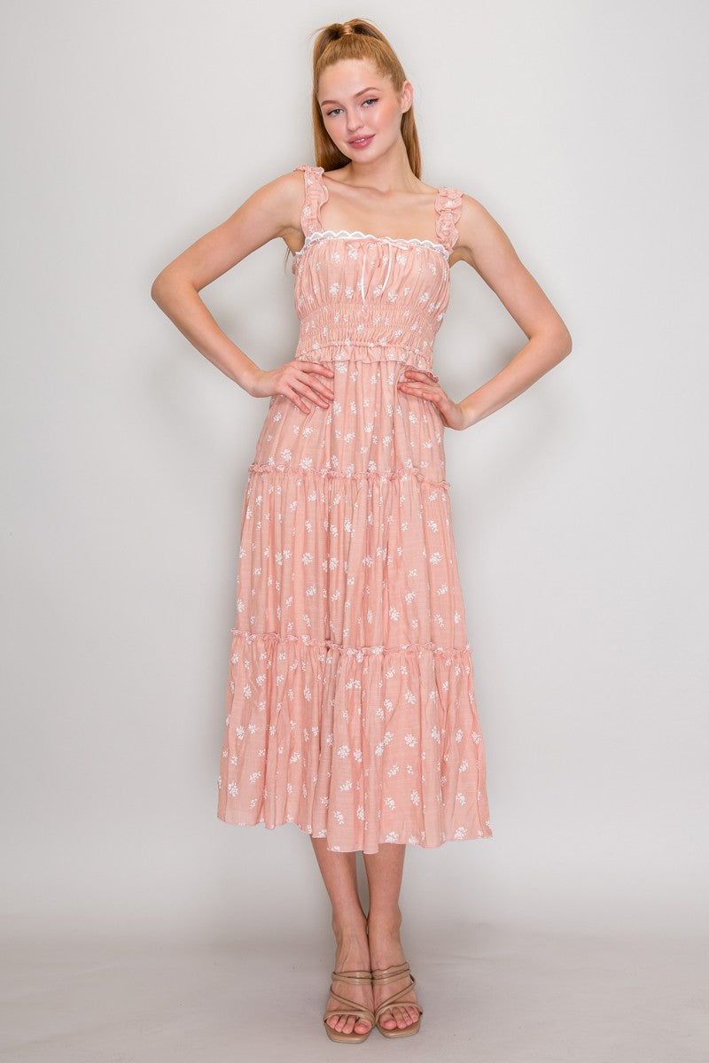 Blush ditsy-floral-print ruffle-strap scallop-lace-trim ribbon-tie smocked-bodice tiered midi dress - front full-length view showing wide ruffled shoulder straps, white scallop lace neckline trim with satin ribbon bow, gathered smocked bodice, ruffled waist flounce, and voluminous tiered chiffon midi skirt in blush ditsy floral print