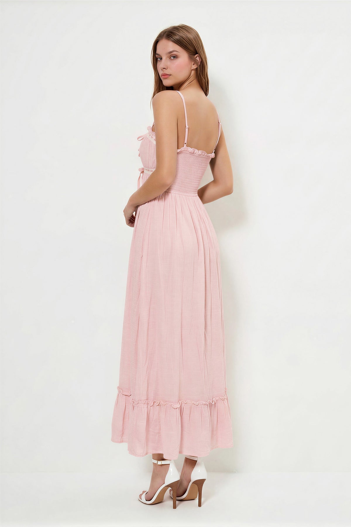 Blush spaghetti-strap ruffle-neckline crochet-lace-trim tie-front gathered-bodice ruffle-hem midi dress - back three-quarter view showing fine adjustable spaghetti straps with metal hardware, low open back, and pleated midi skirt with ruffle hem from behind in soft dusty blush pink