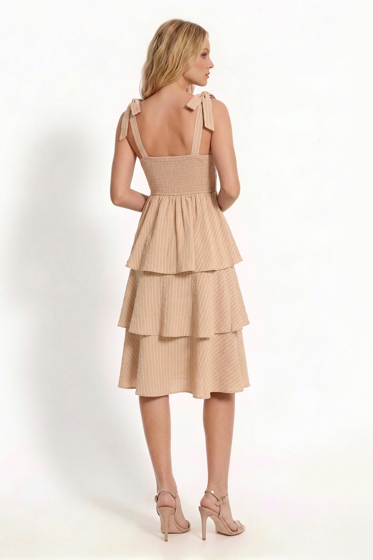 Beige shoulder-tie-strap ruched-bust smocked-waist three-tier midi dress - close-up front bodice detail showing wide straps with signature self-tie shoulder bows, softly ruched and gathered bust panel, and structured smocked waistband in warm sandy beige crinkle