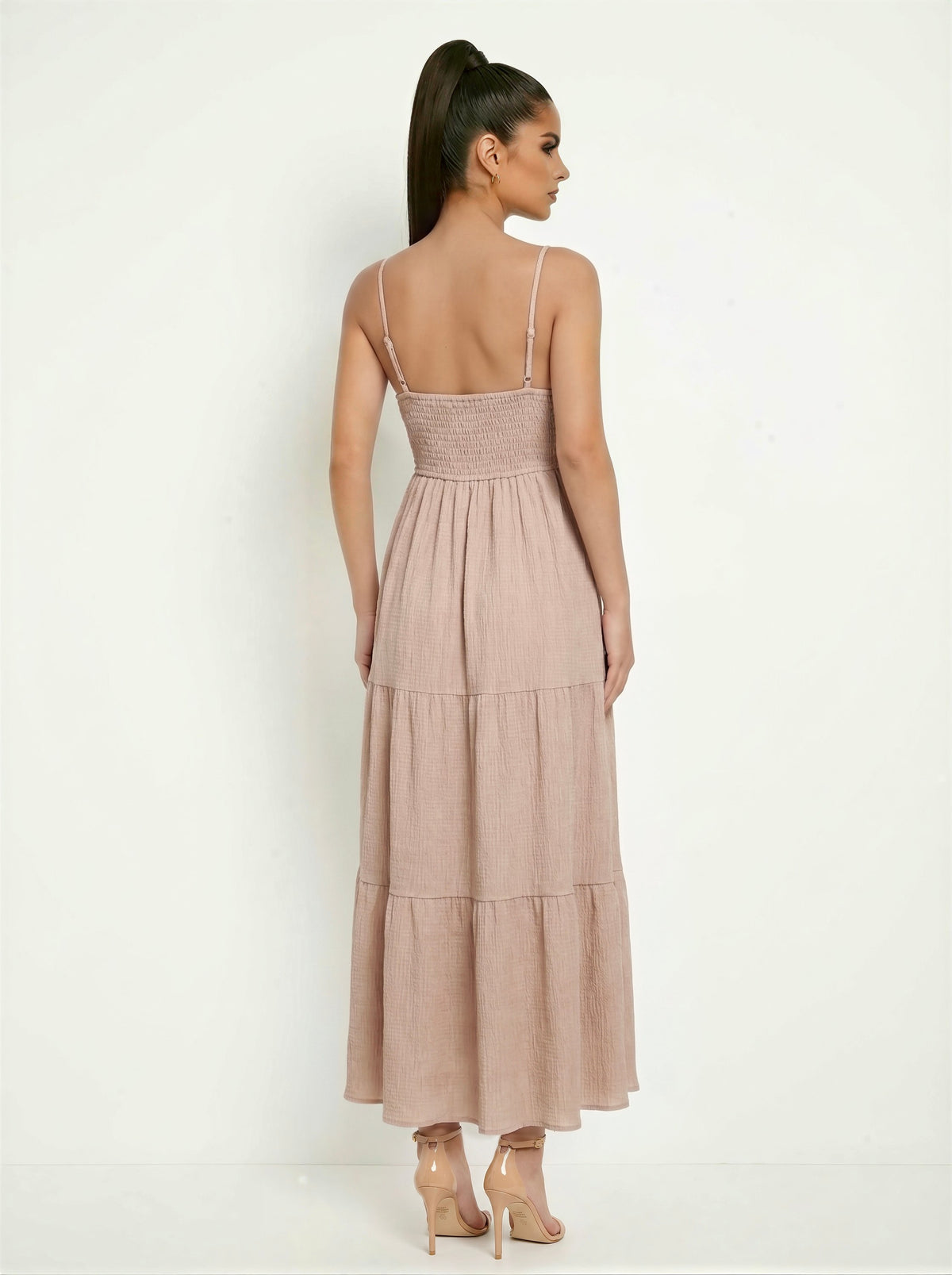 Taupe spaghetti-strap deep-V crochet-bodice button-front scallop-hem smocked-back tiered maxi dress - back full-length view showing fine adjustable spaghetti straps with metal hardware, densely smocked back bodice, and voluminous two-tier crinkle maxi skirt from behind in warm taupe-rose