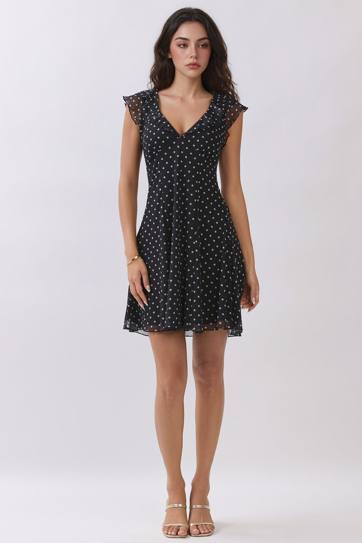 Black polka-dot chiffon deep-V ruffle-sleeve back-tie fit-and-flare mini dress - front full view showing deep V neckline, double ruffle cap sleeves, and flared skirt