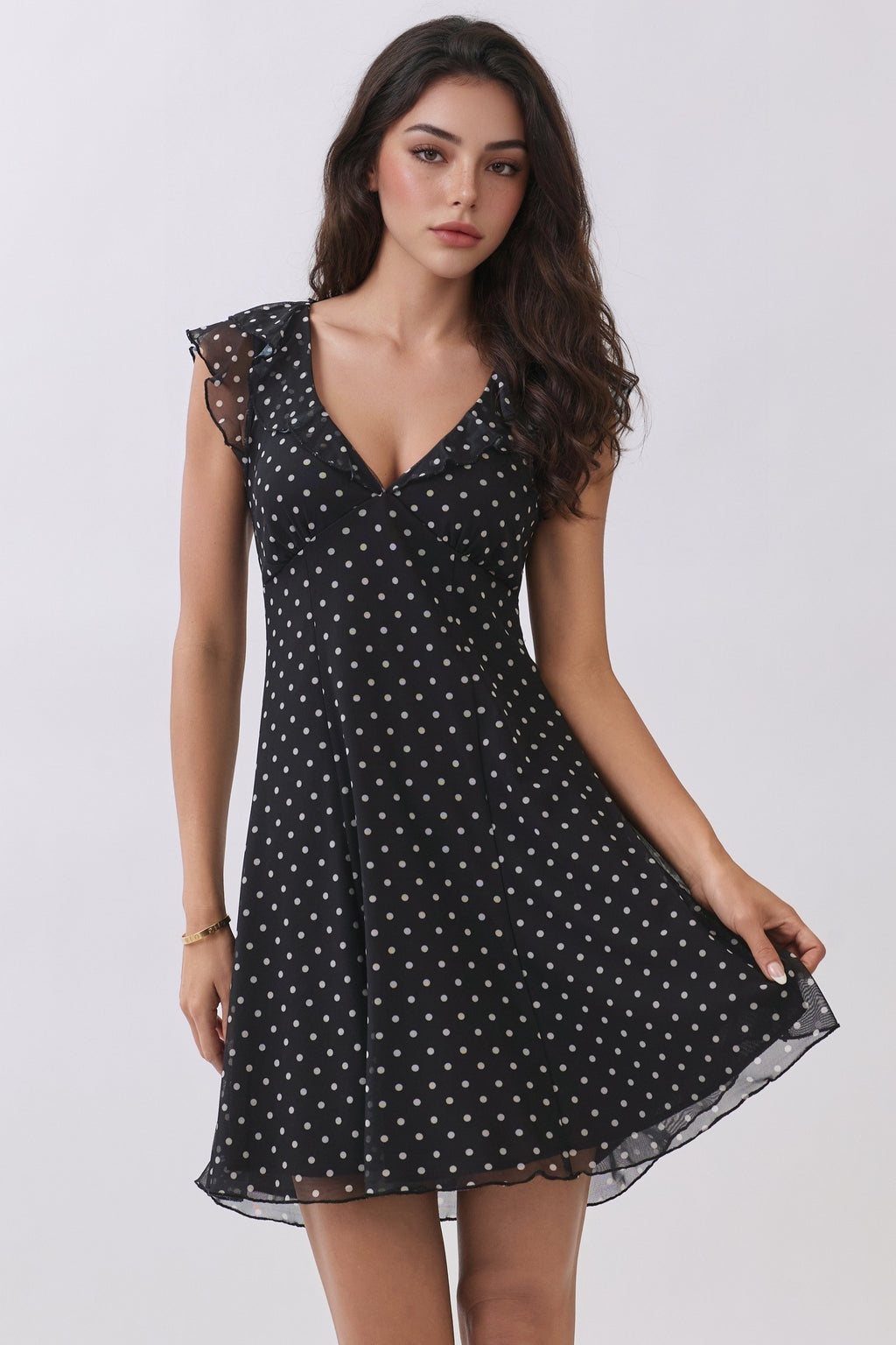 Black polka-dot chiffon deep-V ruffle-sleeve back-tie fit-and-flare mini dress - three-quarter front view showing deep V neckline, ruffle sleeves, and fit-and-flare silhouette
