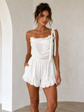 White eyelet-bodice shoulder-tie ruffle-trim elasticated-waist ruffle-hem short romper - front full view showing eyelet bodice, shoulder ties, ruffle trim, and ruffle hem