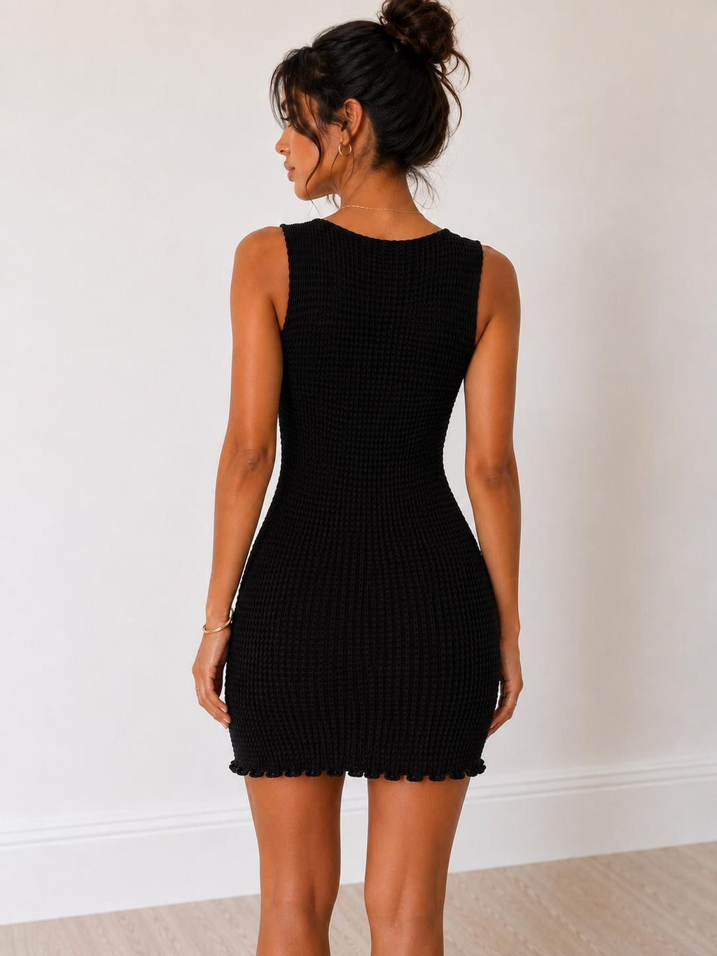 Black waffle-knit sleeveless deep-V front-tie cutout lettuce-edge bodycon mini dress - back view showing round back neckline, wide straps, and fitted bodycon back