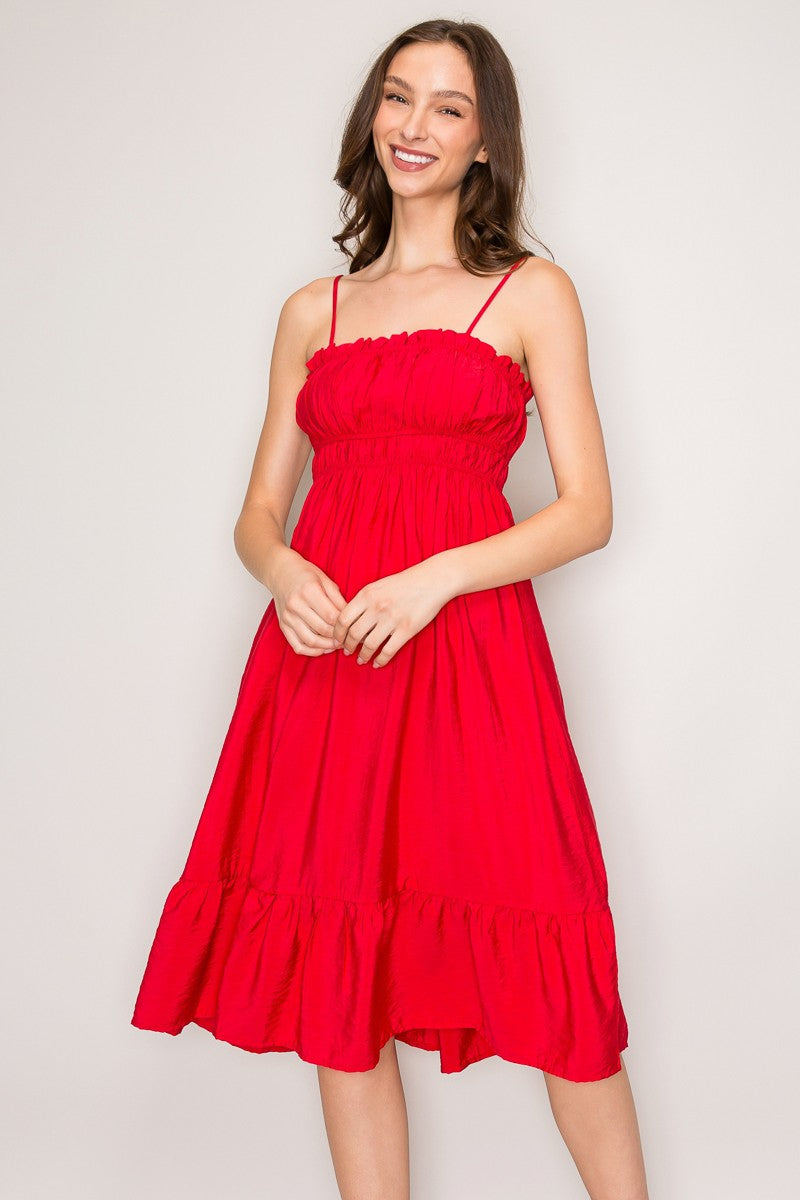 Red spaghetti-strap ruffle-trim smocked-bodice tiered midi dress - close-up front bodice detail showing fine spaghetti straps, delicate gathered ruffle neckline trim, and dense horizontal smocked bodice rows in vivid red