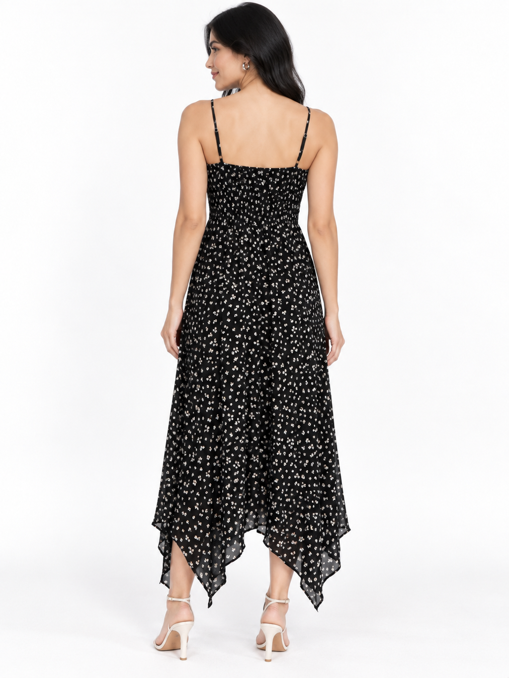 Navy ditsy-floral spaghetti-strap smocked-back handkerchief-hem midi dress - front three-quarter white background view showing fine spaghetti straps, softly scooped V-neckline, and voluminous flowing handkerchief-hem skirt in deep navy with white ditsy florals with nude heels