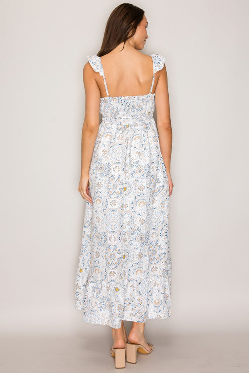 White botanical tile-print square-neck ruffle-strap smocked-bodice tiered midi dress - back full-length view showing wide ruffle-edged straps, open smocked back bodice, and full tiered A-line midi skirt from behind in white botanical tile print