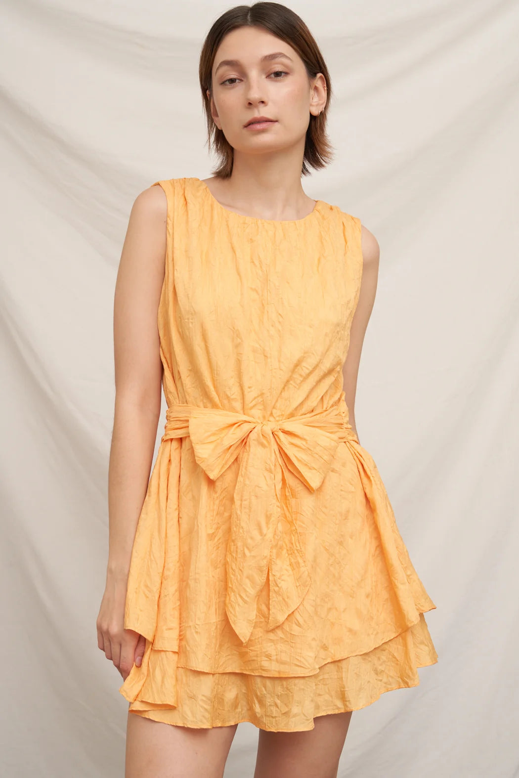 Peach mango textured dot bow-tie waist tiered sleeveless mini dress - front view