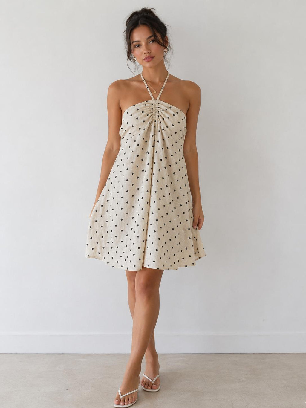 Cream polka dot halter gathered-bust smocked-back open-back babydoll mini dress - back view showing fully open back and smocked waistband