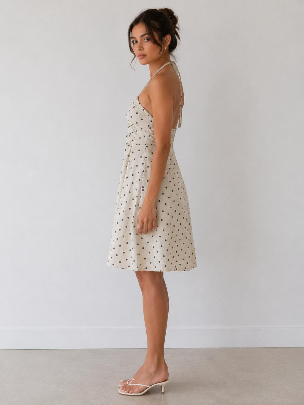 Cream polka dot halter gathered-bust smocked-back open-back babydoll mini dress - side view one showing babydoll silhouette