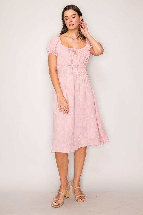Blush pink crinkle-woven sweetheart-neck front-tie puff-sleeve smocked-waist fit-and-flare midi dress - three-quarter front view showing puff sleeves, smocked waist, and full skirt