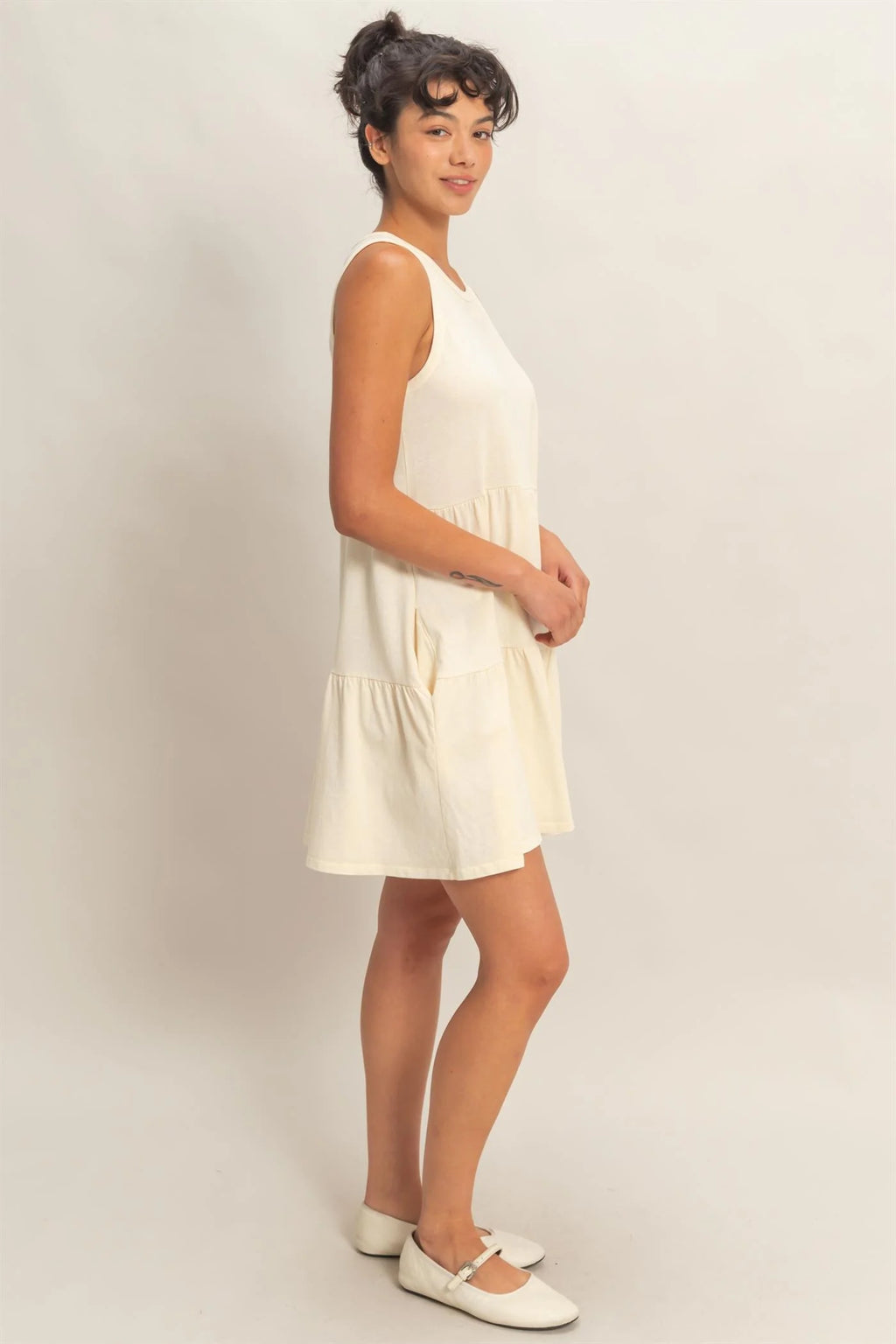 Cream sleeveless tiered babydoll mini dress - side view