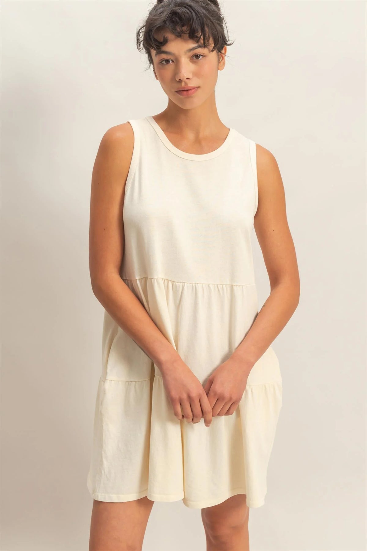 Cream sleeveless tiered babydoll mini dress - front view