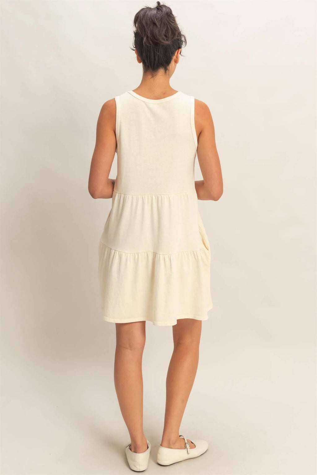 Cream sleeveless tiered babydoll mini dress - back view