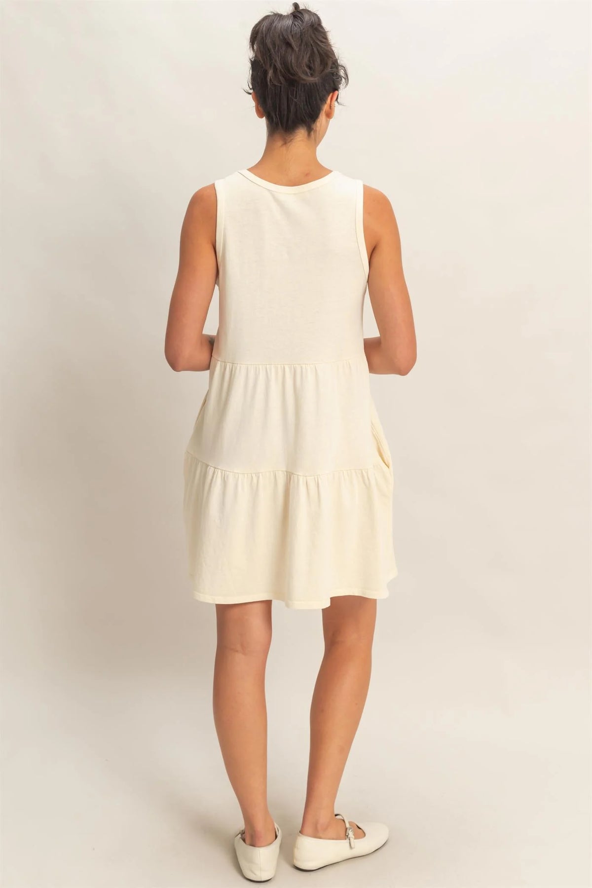 Cream sleeveless tiered babydoll mini dress - back view